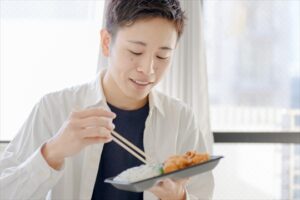 宅配弁当を食べる男性学生